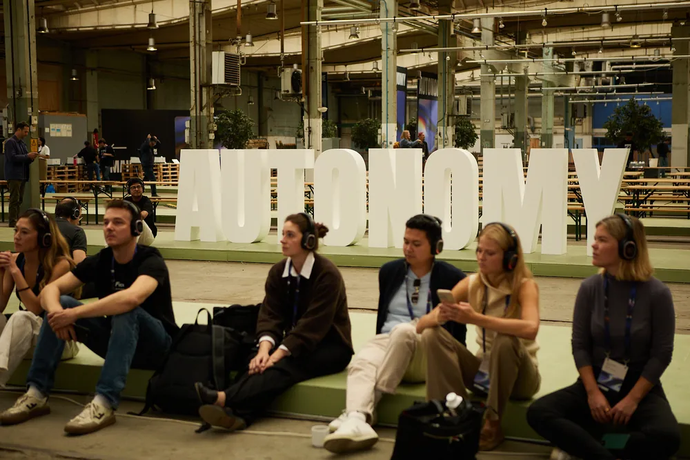 Attendees seated on the steps in front of the large AUTONOMY letters at Lokstallarna
